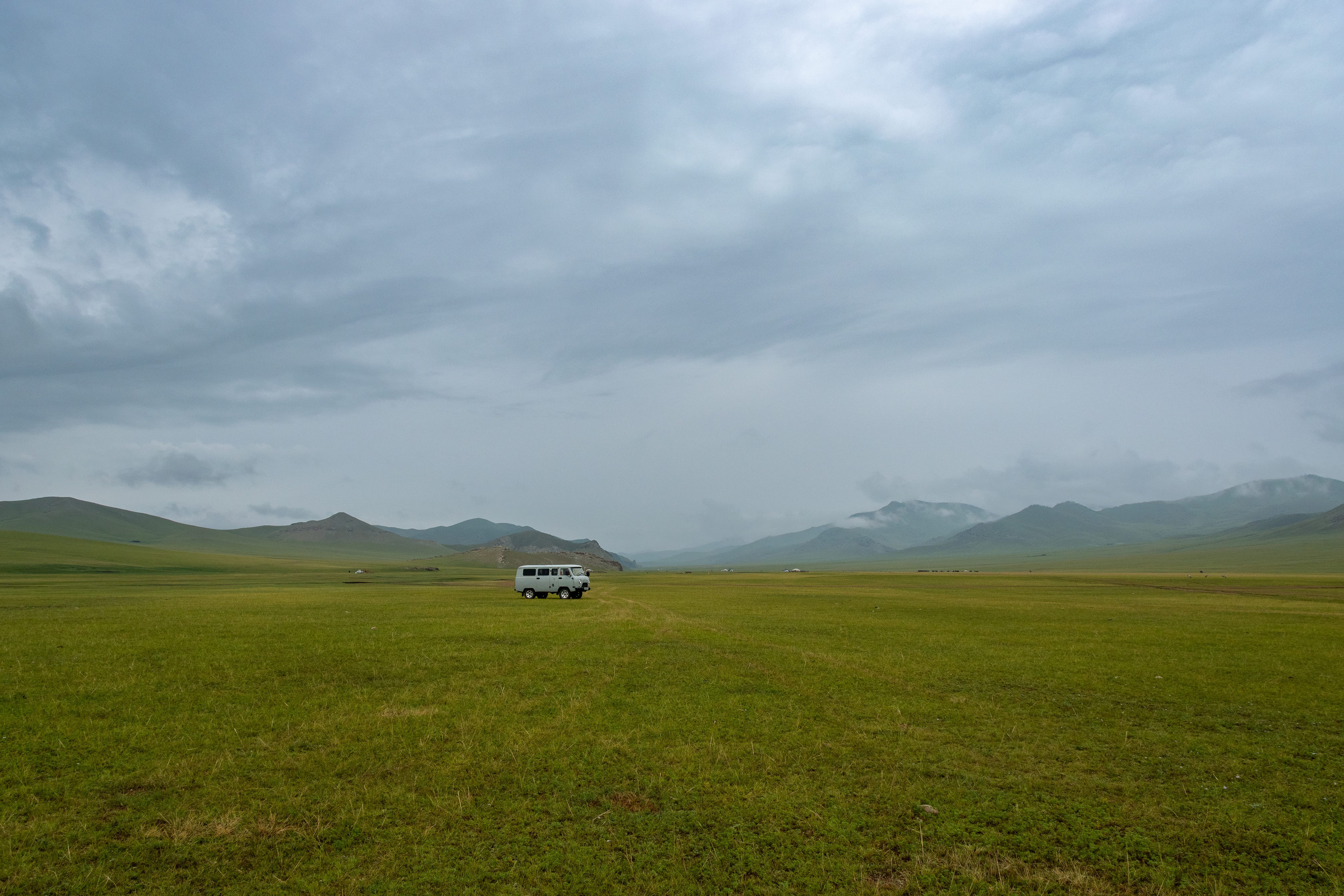 A Van parked on a vast Mongolian field