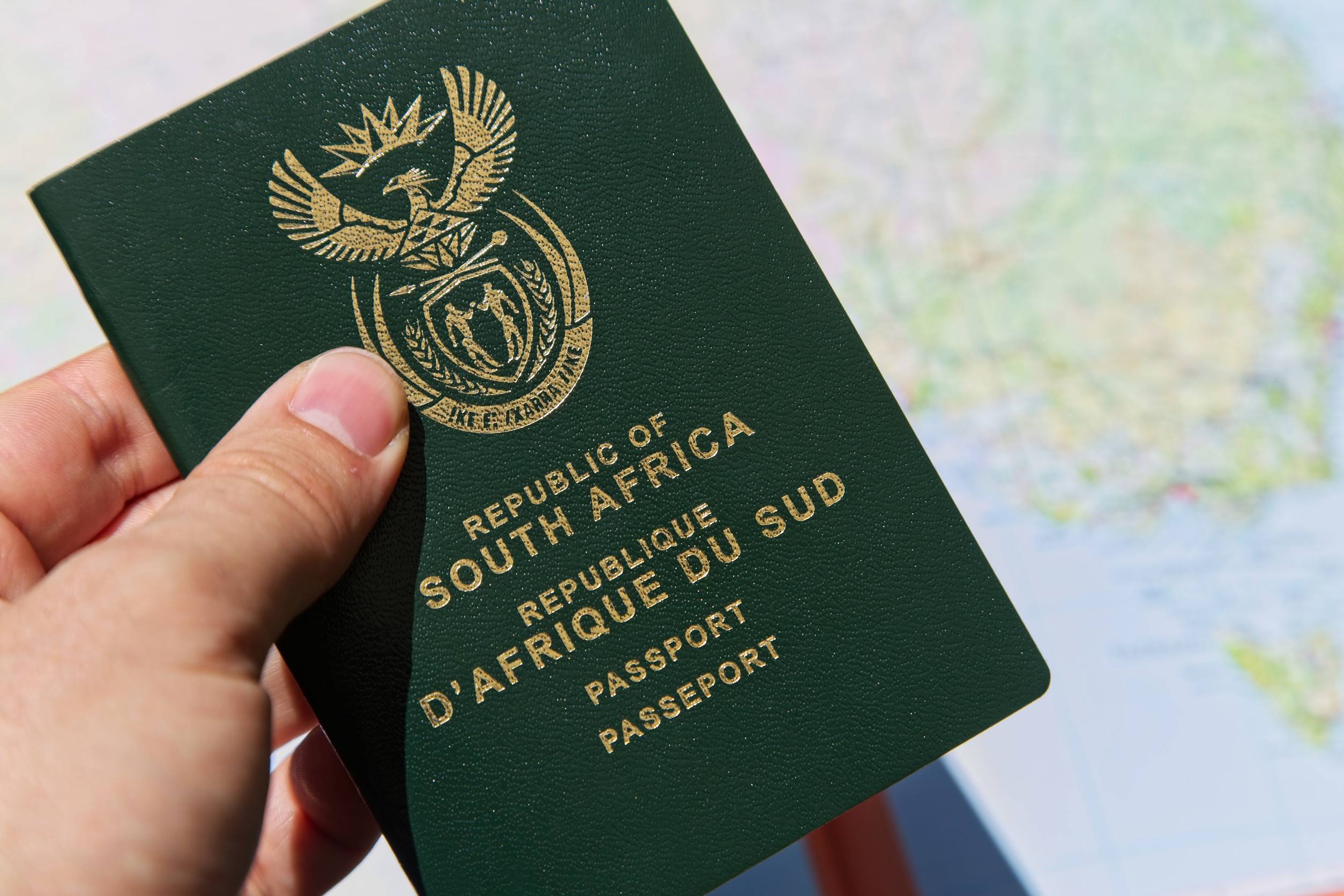Hand holding a South African passport